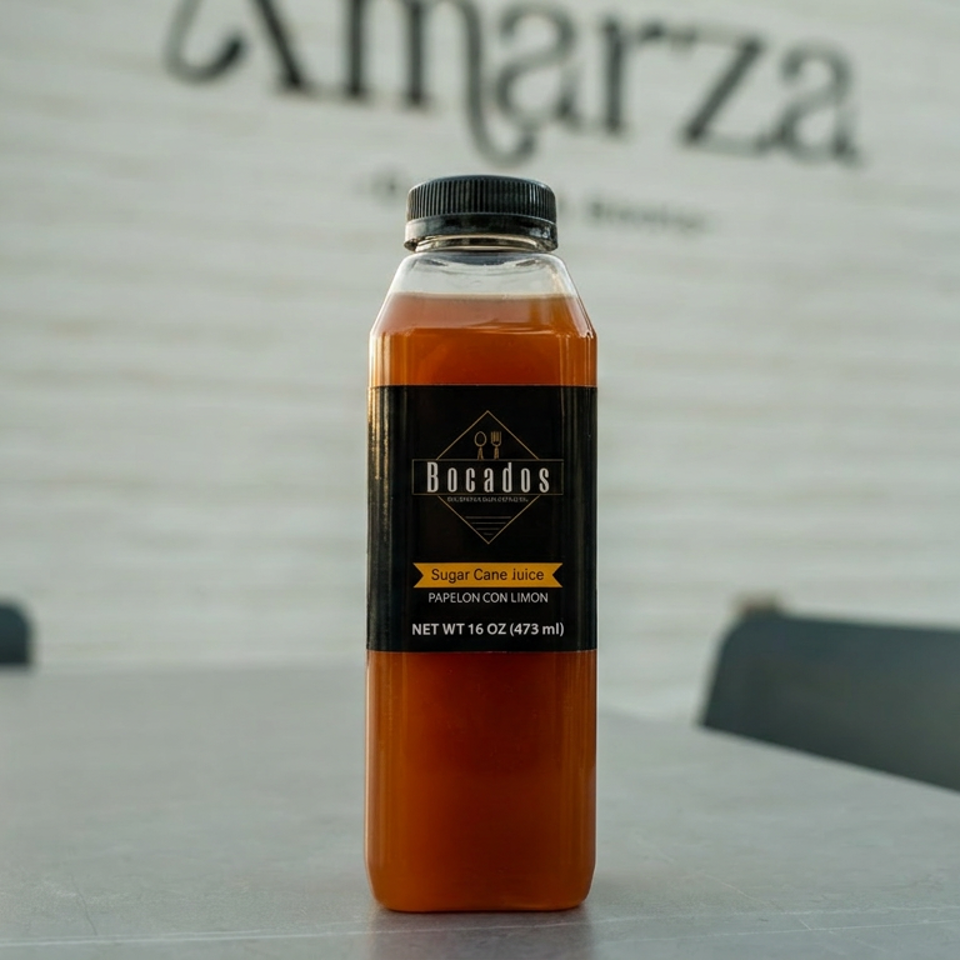 Bocados sugar cane juice bottle on a table with "Amarza" restaurant sign in the background.